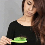woman looking at hair on brush